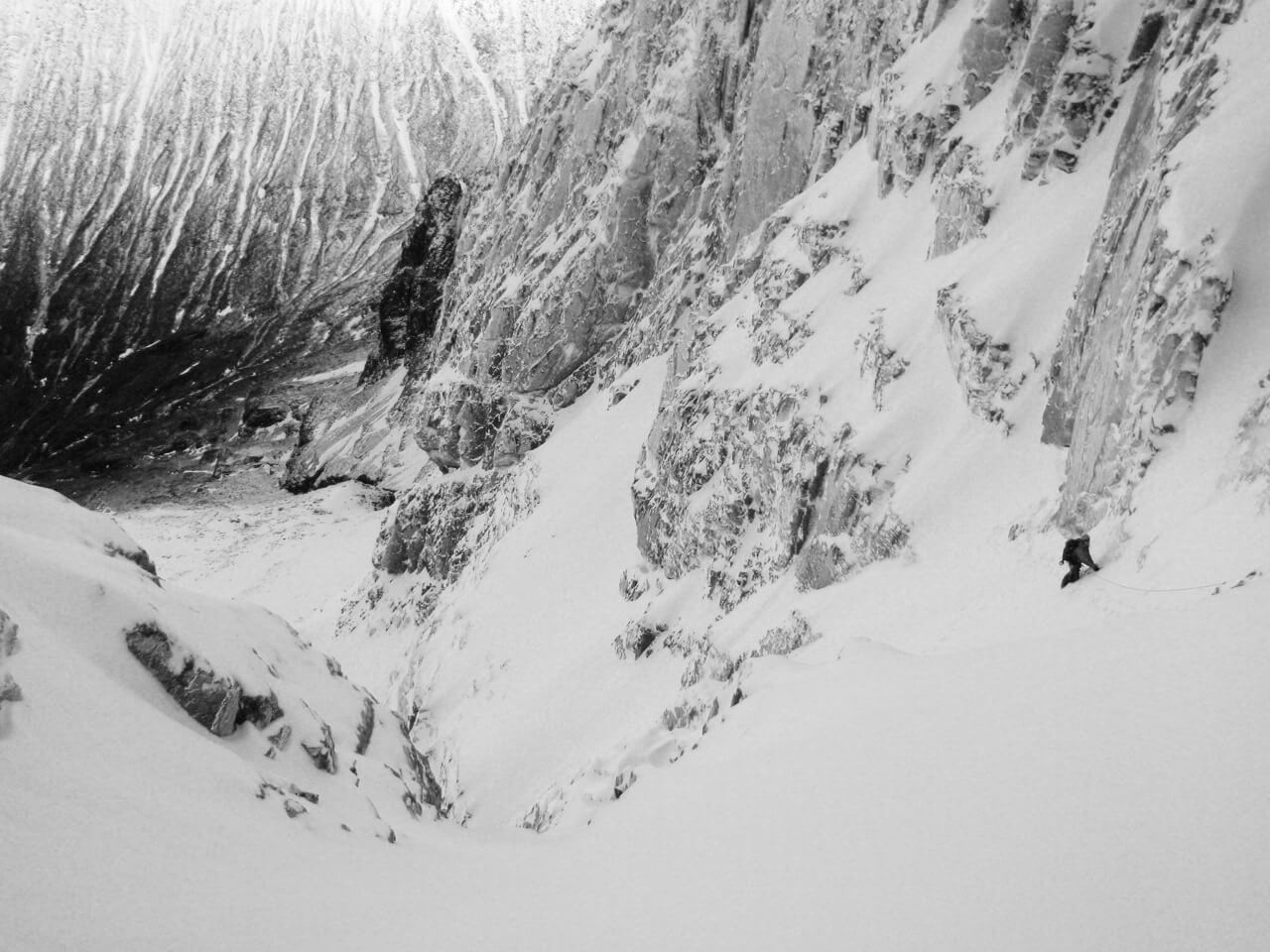 A climber in a snow gully in the middle of the route